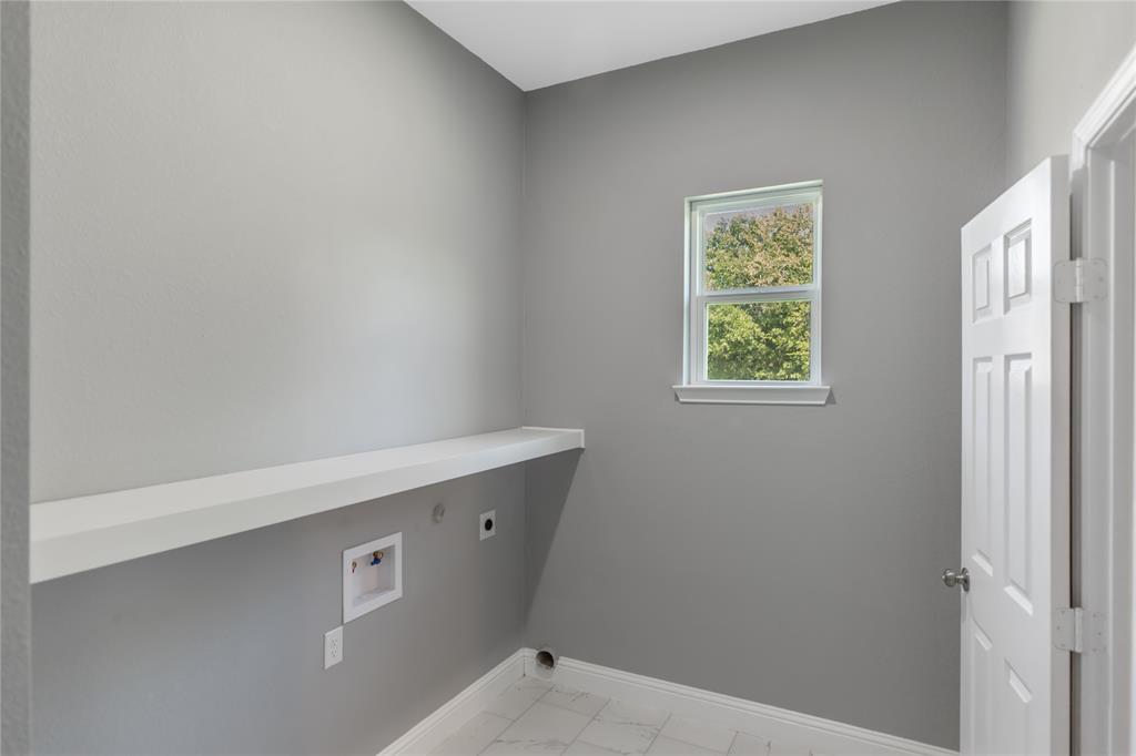 Washroom featuring hookup for an electric dryer, light marble finish flooring, and hookup for a washing machine