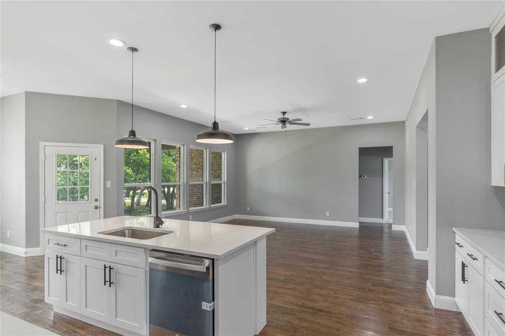 Kitchen with white cabinetry, hanging light fixtures, dishwasher, recessed lighting, and light stone counters