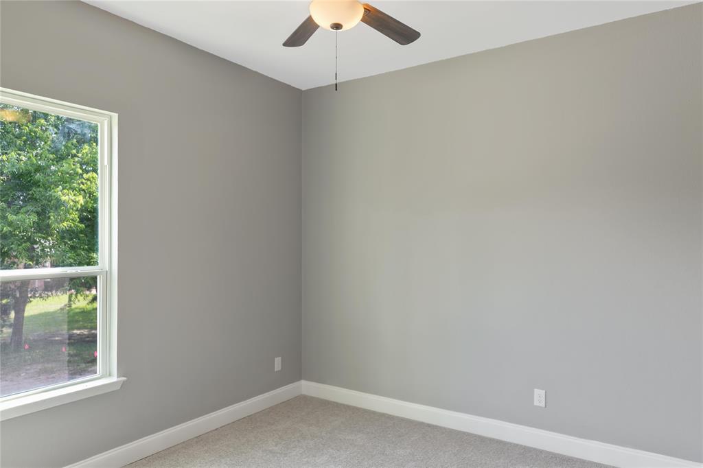 Spare room with carpet floors and a ceiling fan