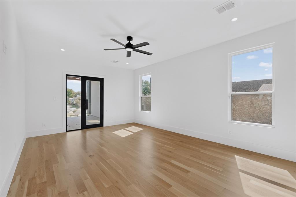 Interior space featuring wood-finish flooring, recessed lighting, a matte black ceiling fan, and a glass-paneled exterior door