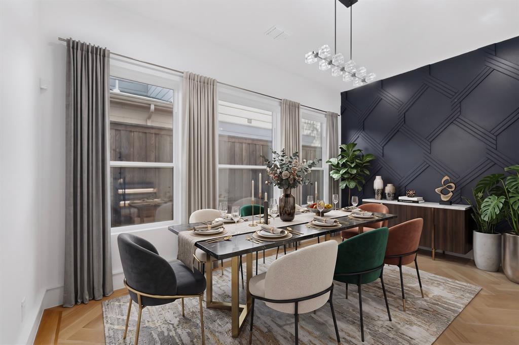 Geometric accent wall with detailed molding, wood-finish flooring in a herringbone pattern, linear multi-light chandelier, and large windows