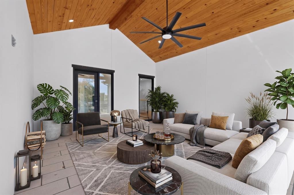 Covered patio featuring a vaulted wood-plank ceiling, recessed lighting, matte black multi-blade ceiling fan, and large-format tile flooring Covered patio featuring a vaulted wood-plank ceiling, recessed lighting, matte black multi-blade ceiling fan, and large-format tile flooring