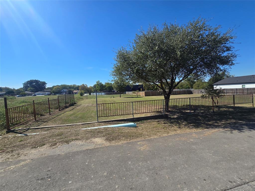 Open lot featuring a fenced perimeter, expansive lawn, and mature tree Open lot featuring a fenced perimeter, expansive lawn, and mature tree
