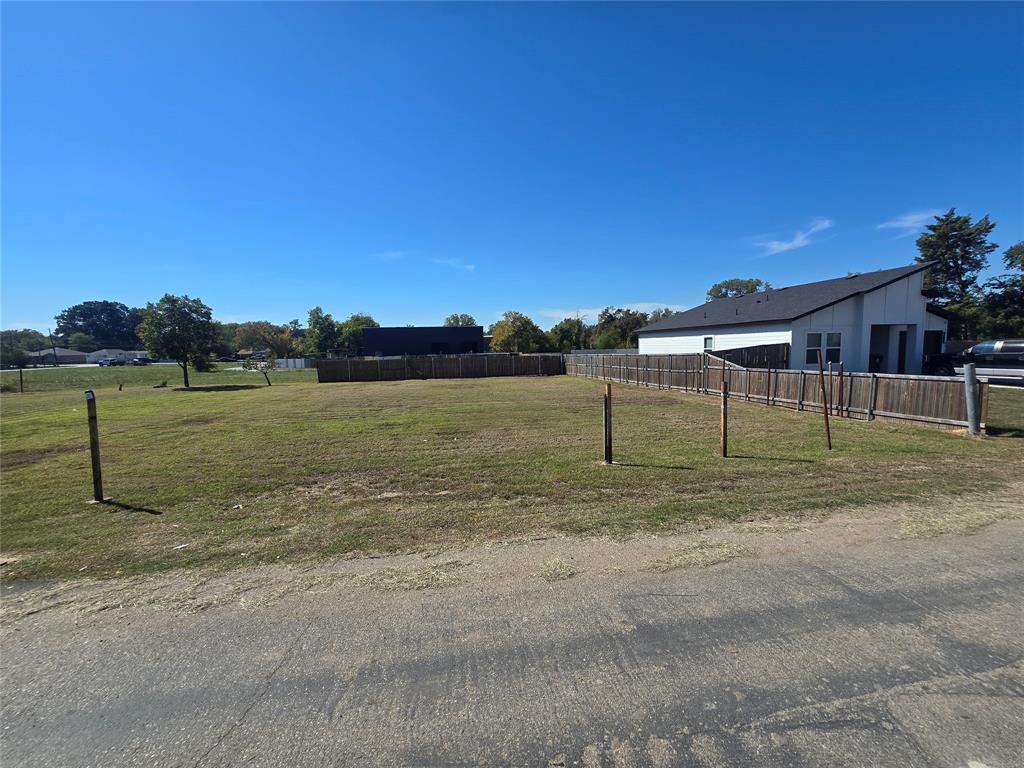 Cleared residential lot featuring a level grass landscape, paved street access, and perimeter wood fencing Cleared residential lot featuring a level grass landscape, paved street access, and perimeter wood fencing