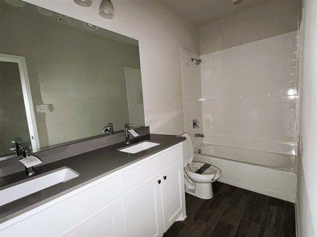 Full bath with quartz counter and traditional tub-shower combo.