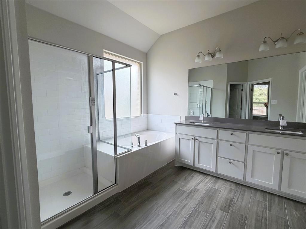 Primary bathroom boasts of extended vanity with duel sinks.  After a long day, soak in the garden tub or unwind in the steam of the walk-in shower.