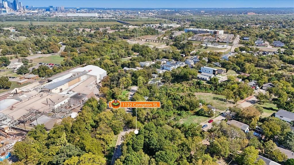 Aerial perspective featuring a wooded lot with mature trees and a paved street