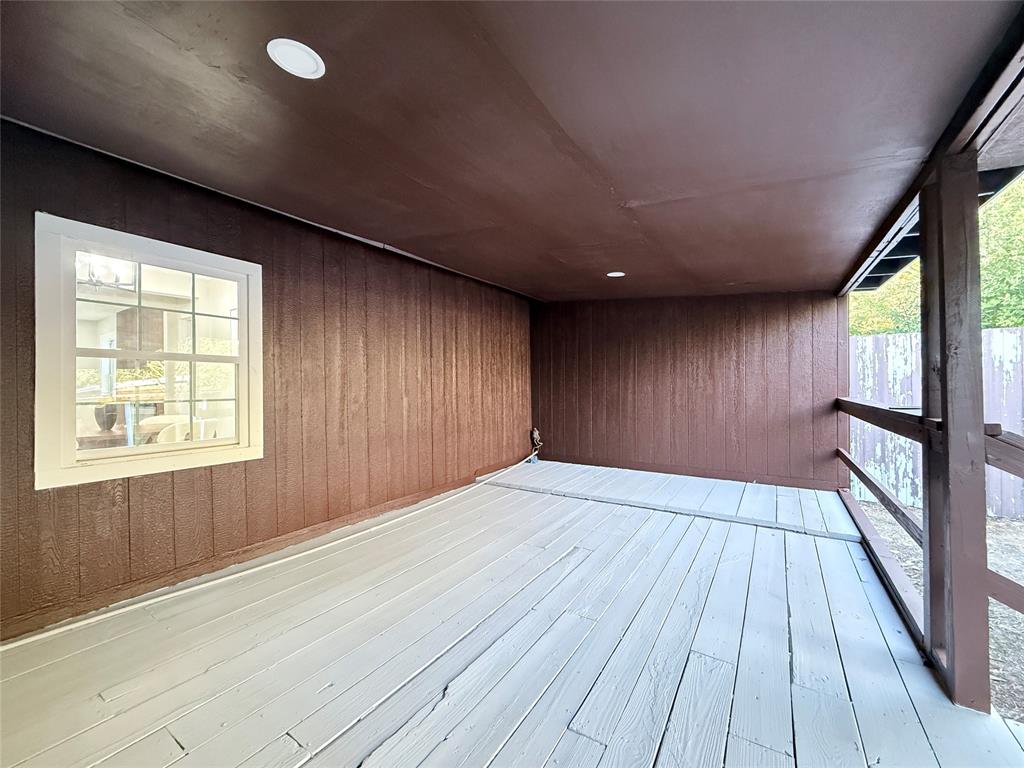 Covered deck featuring wood-panel siding, recessed lighting, and painted wood-plank flooring
