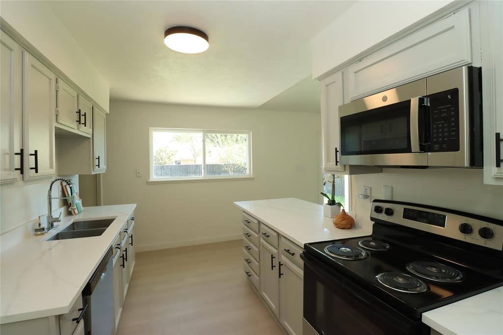New stainless steel microwave, black electric range, and double-basin stainless steel sink with a high-arch pull-down faucet!