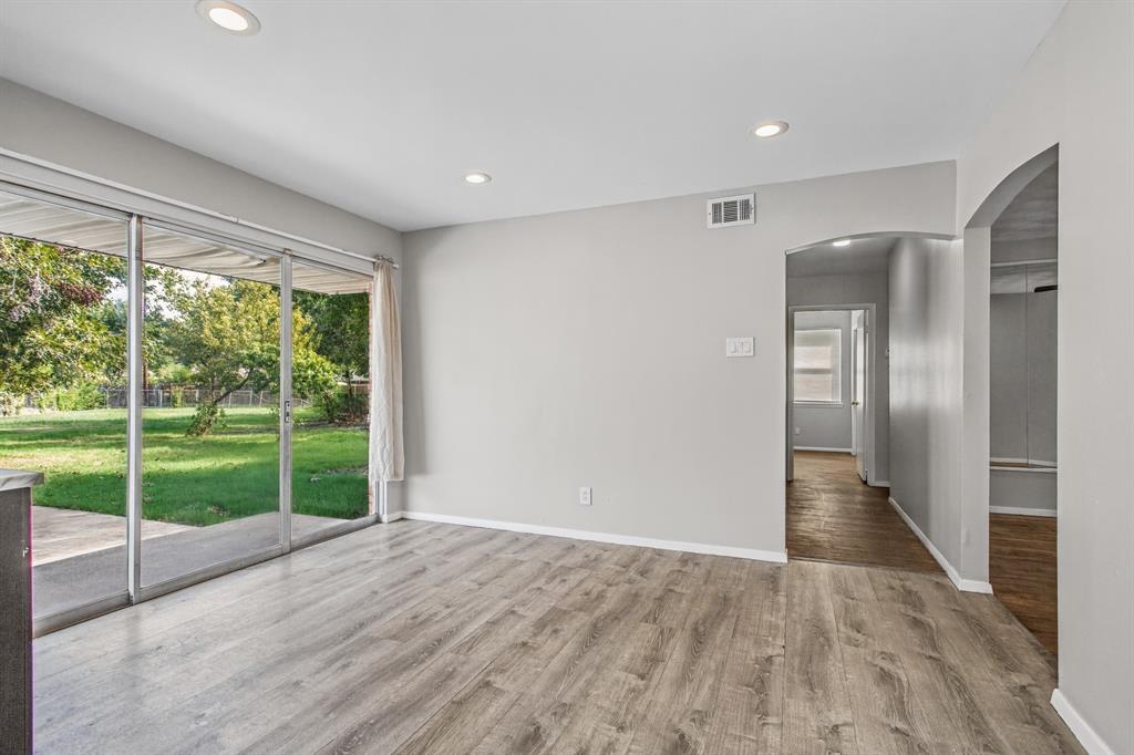 Interior space featuring wood-finish flooring, recessed lighting, and large sliding glass doors opening to a backyard
