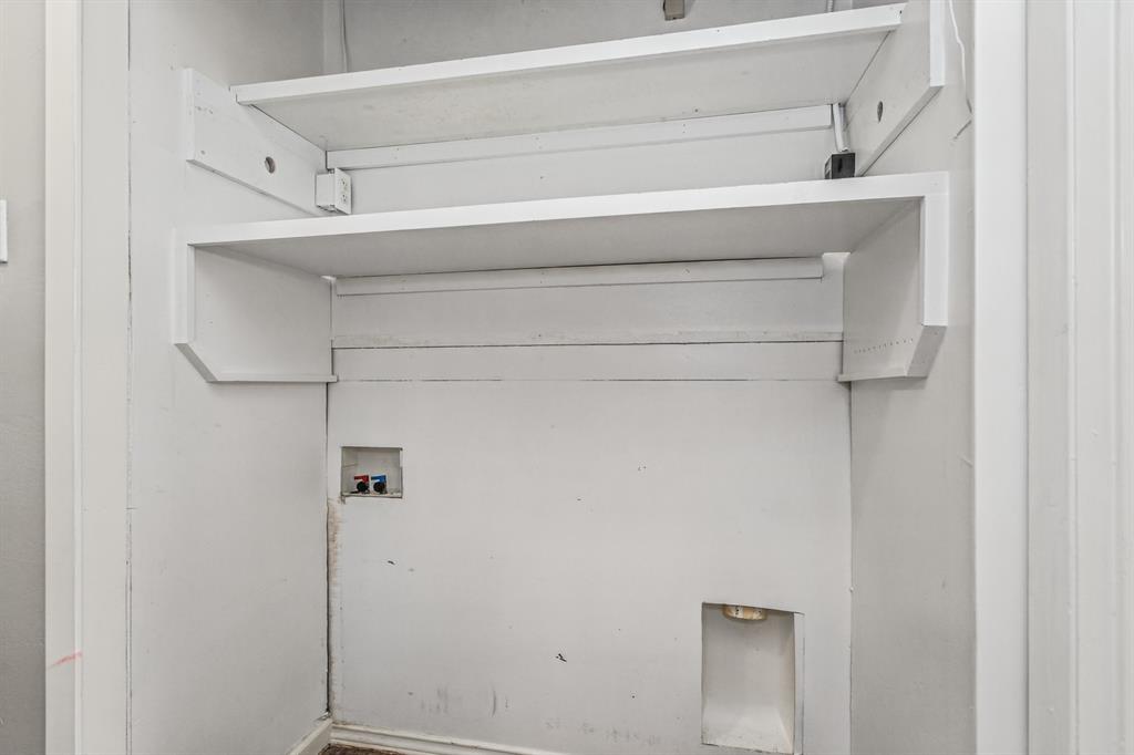 Recessed utility hookups featuring dual built-in white shelving units