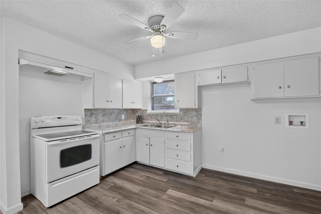 Kitchen featuring white cabinetry, stone-finish countertops, wood-finish flooring, an integrated electric range, and a ceiling-mounted fan Kitchen featuring white cabinetry, stone-finish countertops, wood-finish flooring, an integrated electric range, and a ceiling-mounted fan
