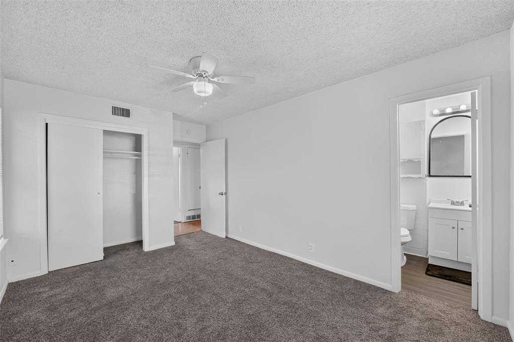 Room featuring wall-to-wall carpeting, ceiling fan with integrated lighting, and sliding-door closet