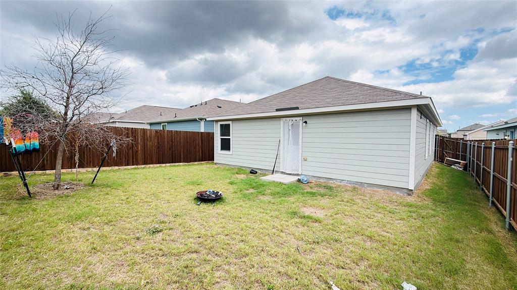 Rear yard featuring horizontal siding, a gabled roof, and wood-panel privacy fencing