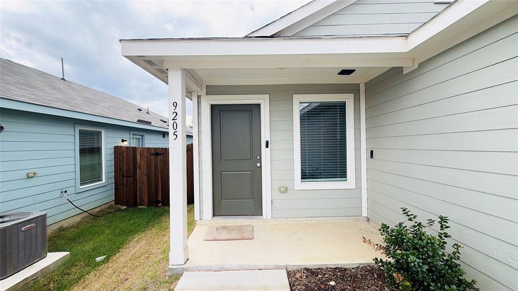 Covered porch entry featuring horizontal lap siding, a solid-panel front door, and a concrete foundation