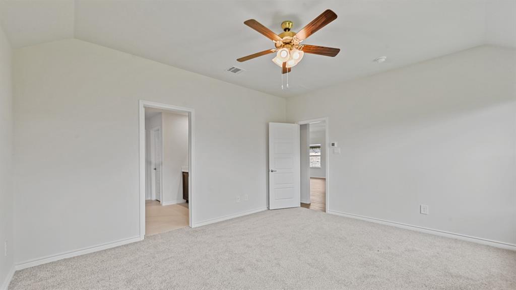 Vaulted ceiling, ceiling fan with integrated lighting, neutral carpet, white walls, and white trim
