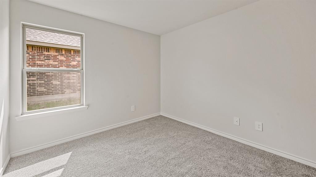 Grey carpeted flooring with light-colored walls and a single window
