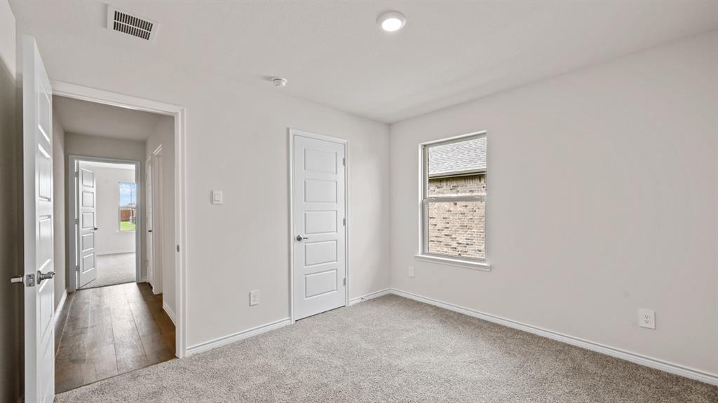 Carpeted room with a single window, white walls, and recessed lighting