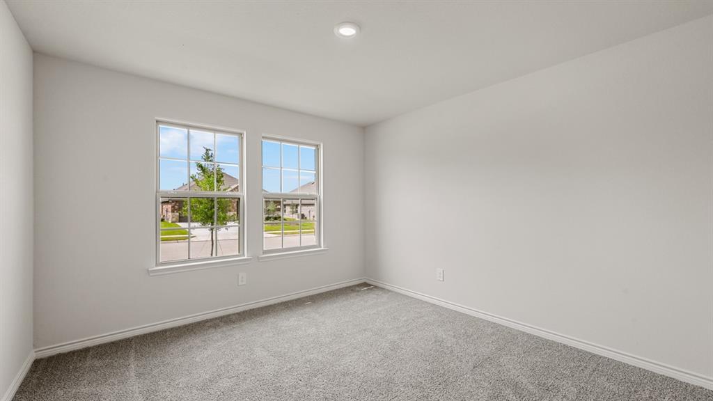 Bright interior space featuring two large windows, recessed ceiling lighting, and grey carpeting