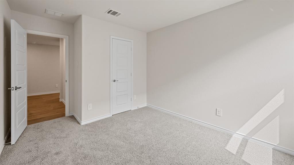 Neutral-toned wall finishes, light-colored carpeting, white interior doors, and modern door hardware