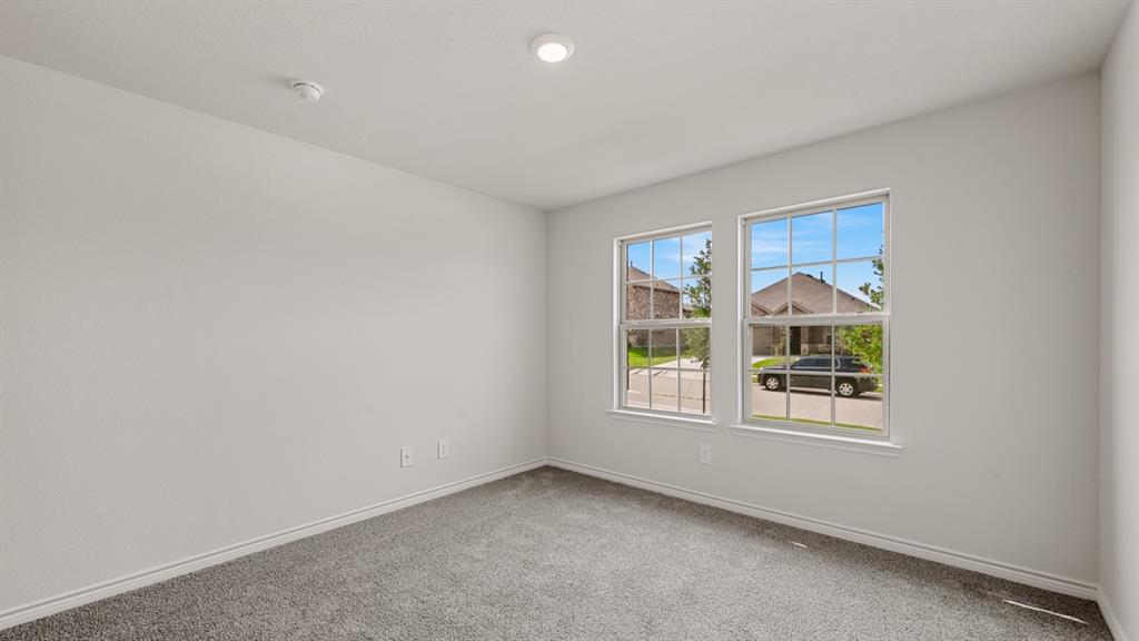 Recessed ceiling light, two large windows, light gray wall paint, gray carpet, and white trim
