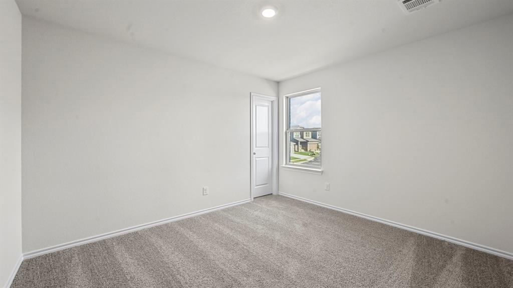 Recessed ceiling light, neutral wall color, window with exterior elements, carpeted flooring, and a white door