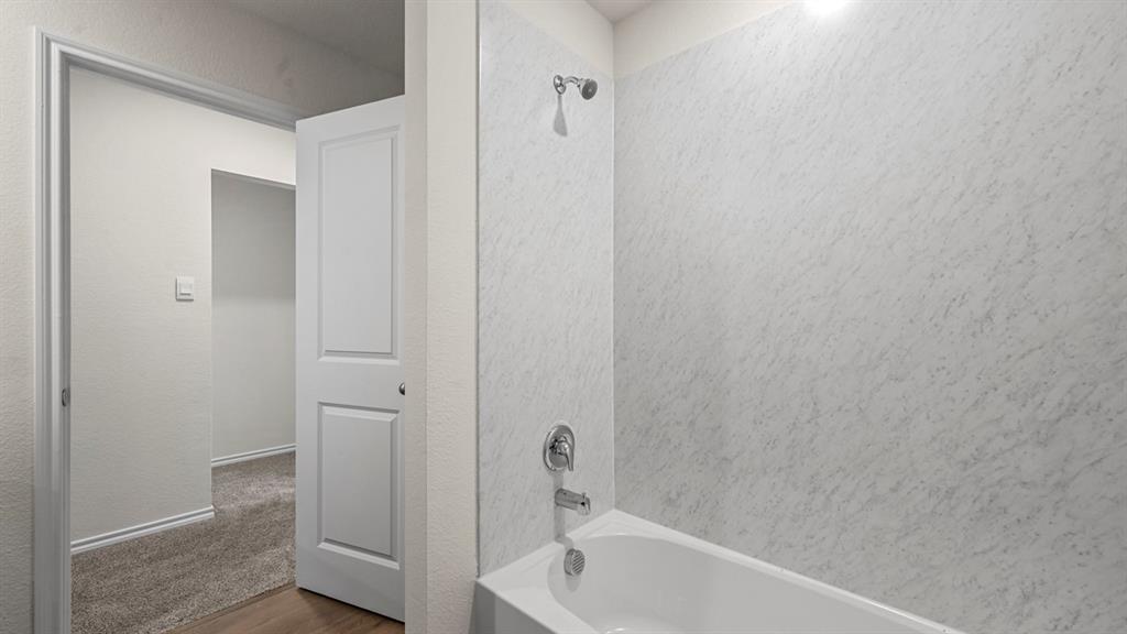 Tub and shower combination with chrome fixtures and light-toned surround