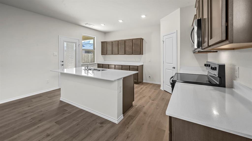 Kitchen featuring a central island, wood-finish flooring, recessed lighting, white countertops, and stainless steel appliances