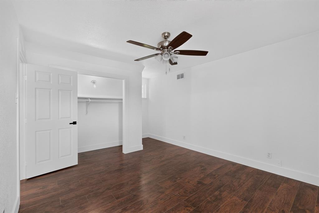 Interior space featuring wood-finish flooring, a five-blade ceiling fan with integrated lighting, and a closet with a built-in rod