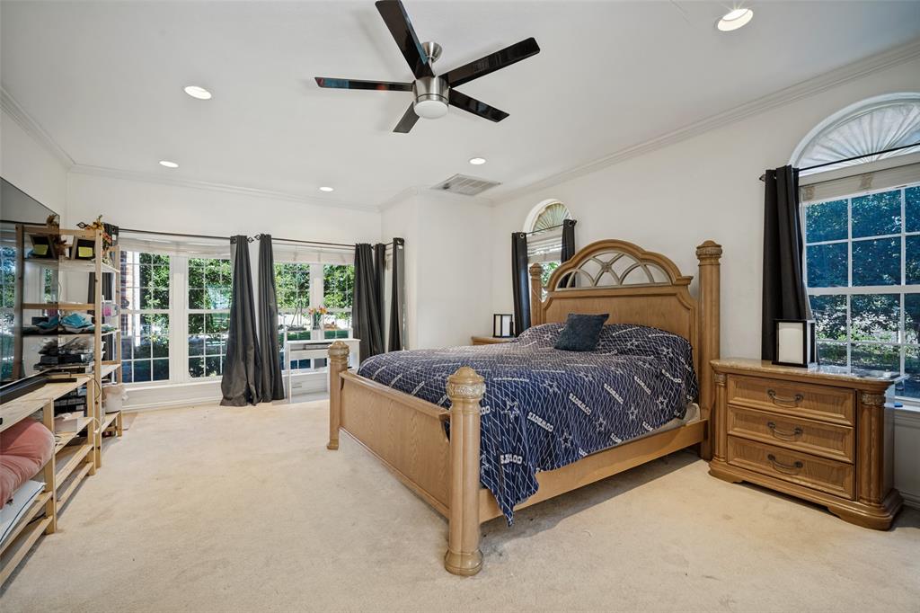 Spacious interior featuring recessed lighting, a modern ceiling fan, crown molding, and large windows with arched transoms