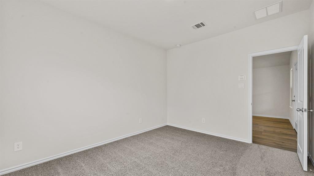 Neutral paint palette, gray carpet, white trim, recessed lighting, wood-finish flooring visible through doorway