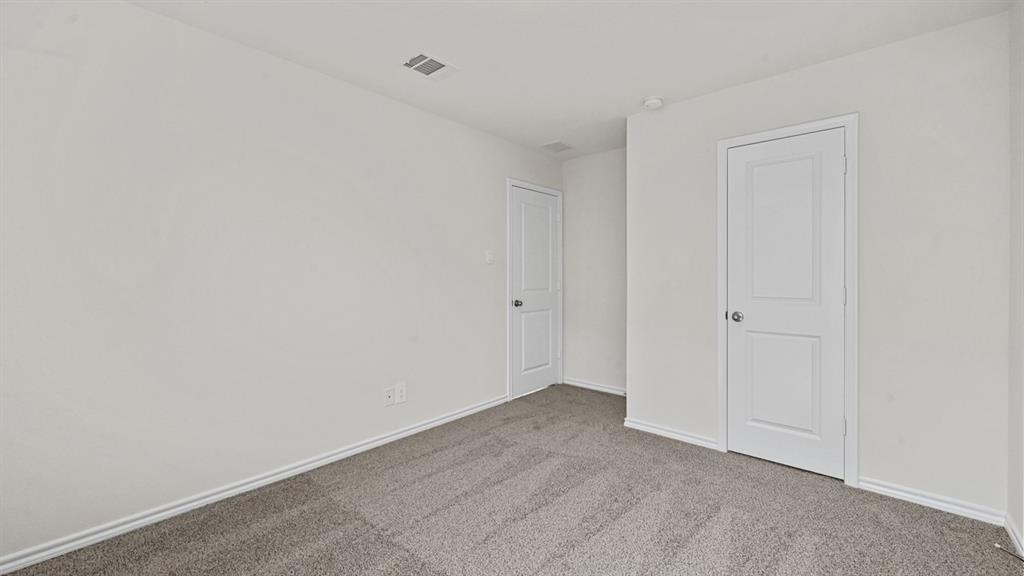 Neutral wall color, grey carpet, and two paneled doors with chrome hardware