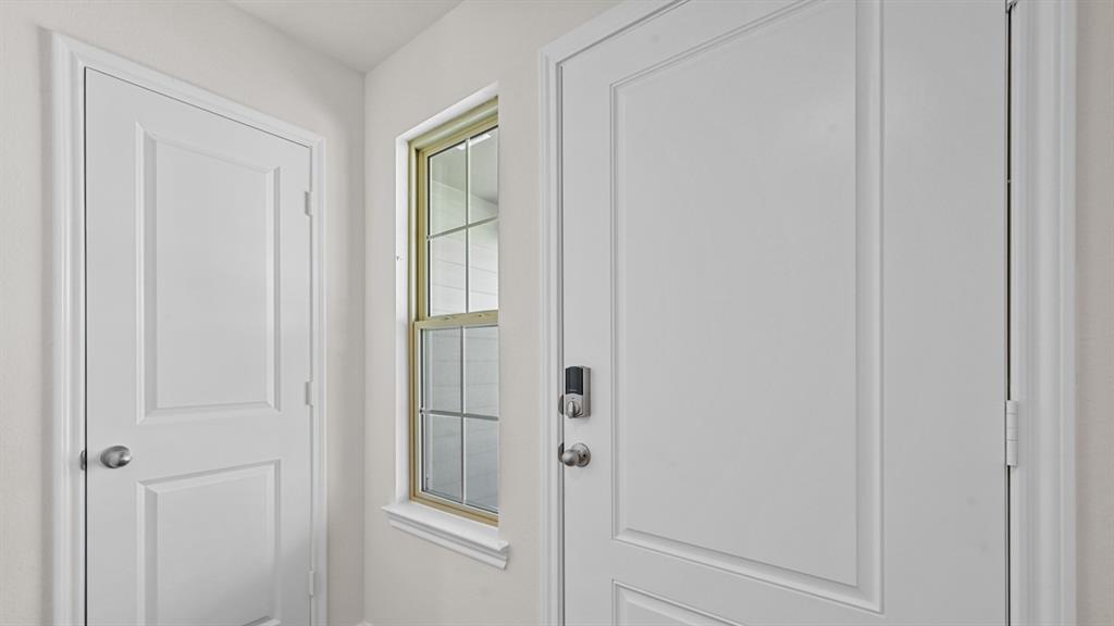 Panel doors with white trim, a window with gridded panes, and a keyless entry system