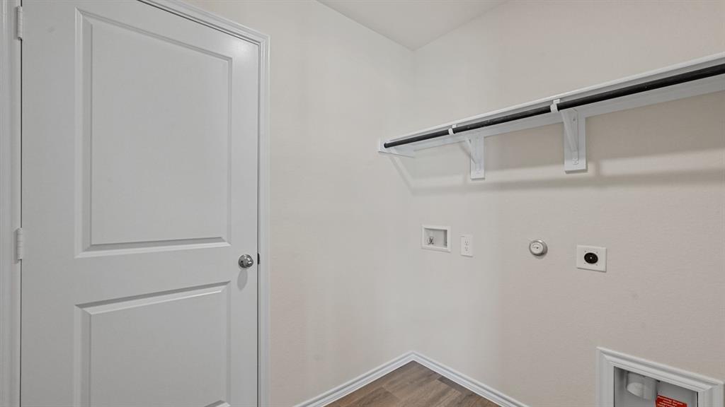 White paneled door, wood-finish flooring, and a mounted shelf and clothing rod