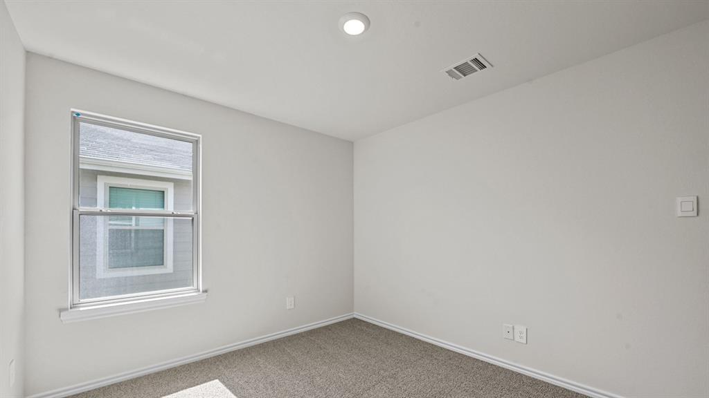 Neutral wall finish, recessed ceiling lighting, light gray carpet, double-hung window with screens, white window trim