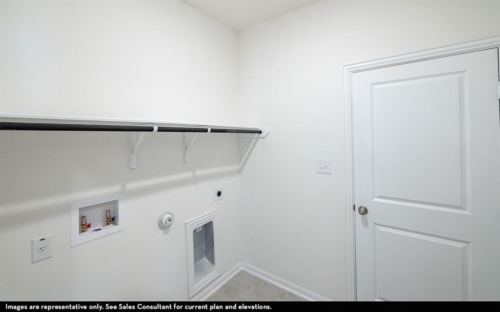 Dedicated utility space featuring a built-in overhead shelf and hanging rod, recessed water supply connection, recessed drain box, and a solid-core interior door