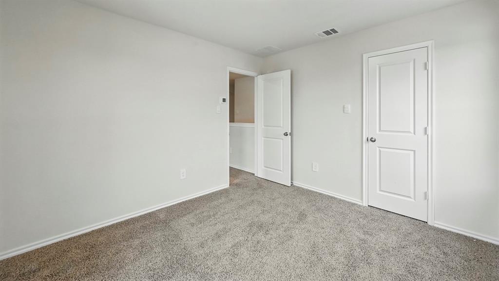 Spacious room featuring neutral carpeting and white baseboards