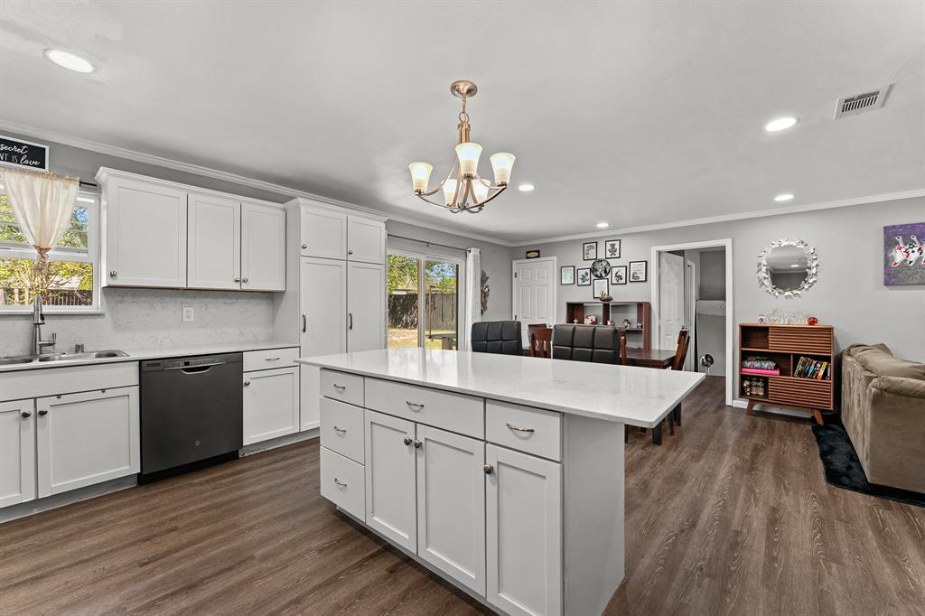 Kitchen featuring white shaker-style cabinetry, quartz countertops, central island, wood-finish flooring, and recessed lighting