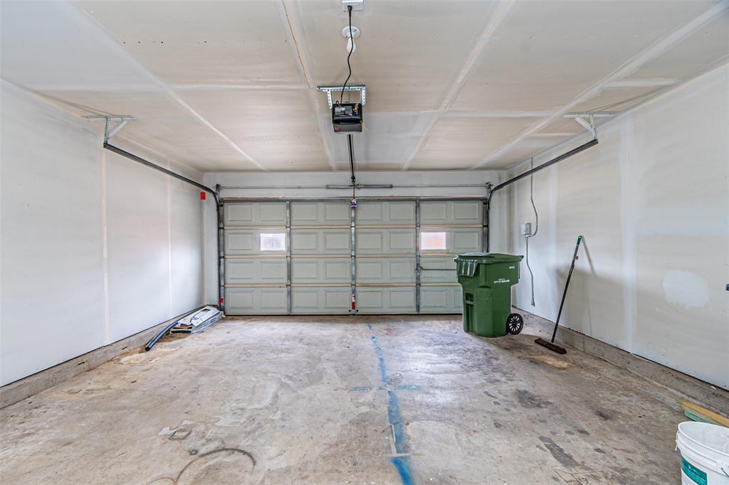 Two-car garage featuring a sectional metal door with inset windows, concrete flooring, and an automated overhead door opener