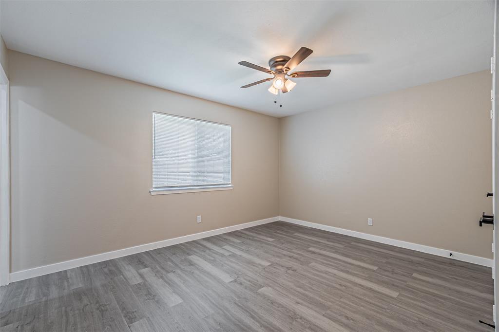 Neutral wall finishes, wood-finish flooring, and a central ceiling fan with integrated lighting