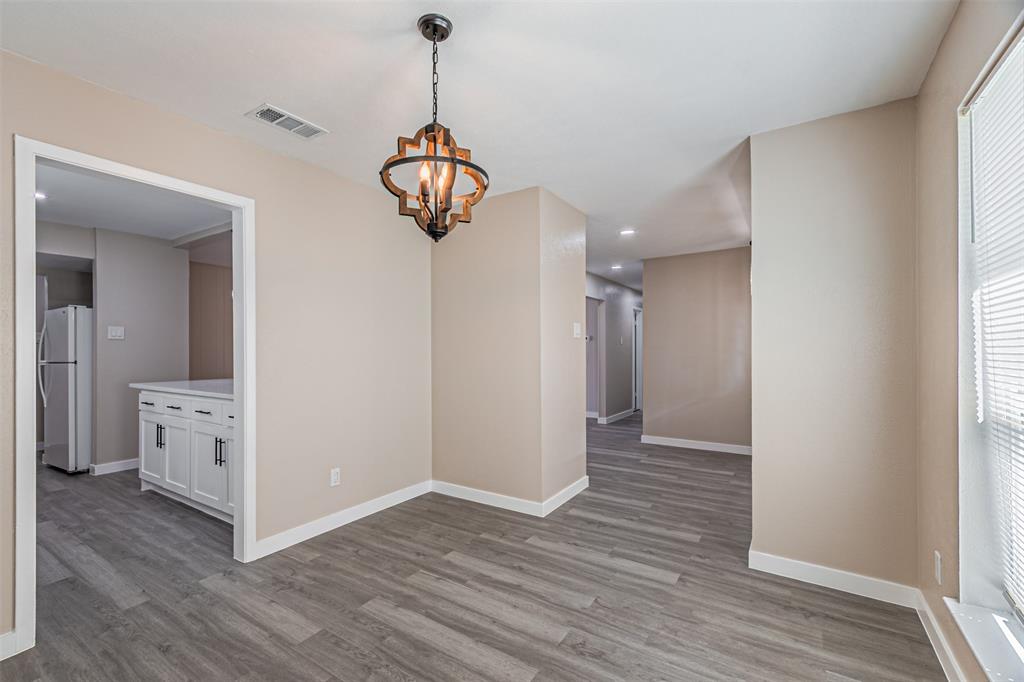 Wood-finish flooring, neutral wall tones, and a multi-light spherical chandelier featuring an open-frame metal and wood design