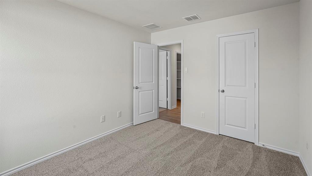 Neutral-toned wall-to-wall carpeting, crisp white walls, and solid-core two-panel interior doors with satin nickel hardware