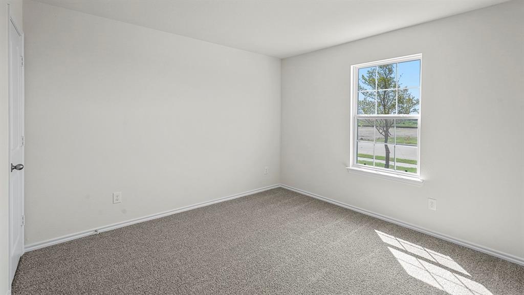 Neutral interior space featuring carpeting, white walls, and a single-hung window Neutral interior space featuring carpeting, white walls, and a single-hung window
