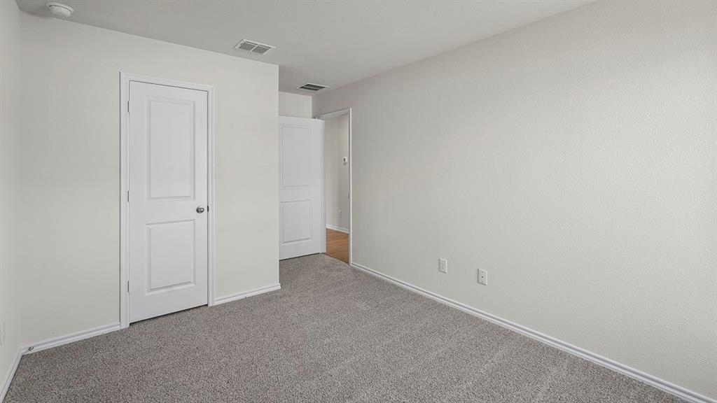 Interior space featuring neutral wall tones, gray carpeting, and white two-panel interior doors
