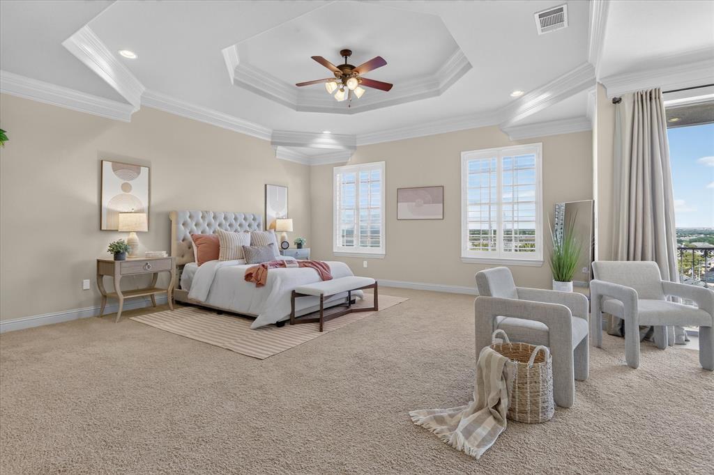 Tray ceiling with crown molding, recessed lighting, central ceiling fan, and multi-pane windows with plantation shutters