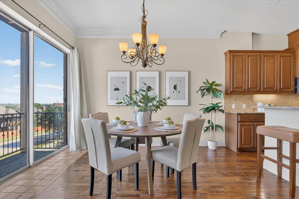 Wood-finish flooring, full-height sliding glass doors, decorative multi-arm chandelier, and natural wood cabinetry