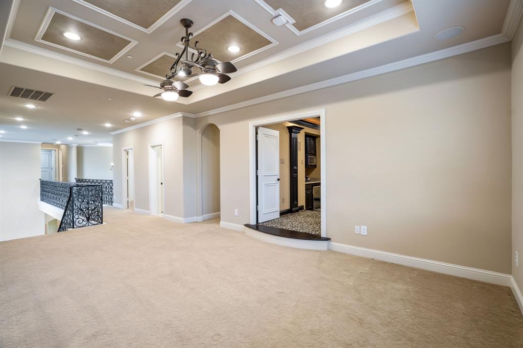 Tray ceiling with recessed lighting, wrought-iron balustrade, and multi-light chandelier fixture