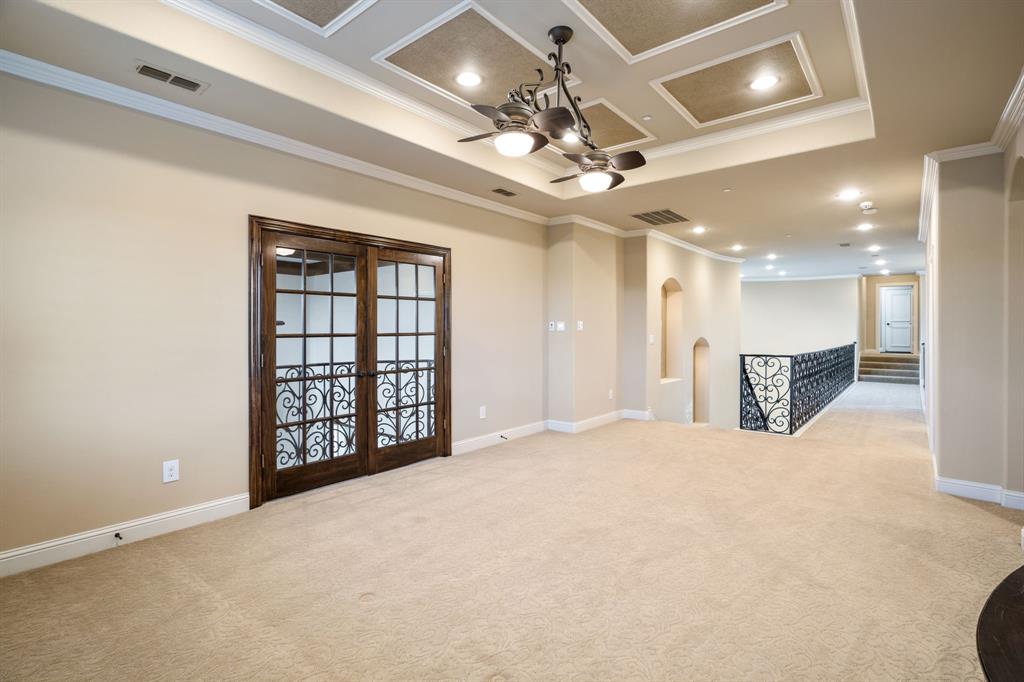 Coffered ceiling featuring recessed lighting, decorative chandelier, double French doors with glass panes, and ornate metal stair railing