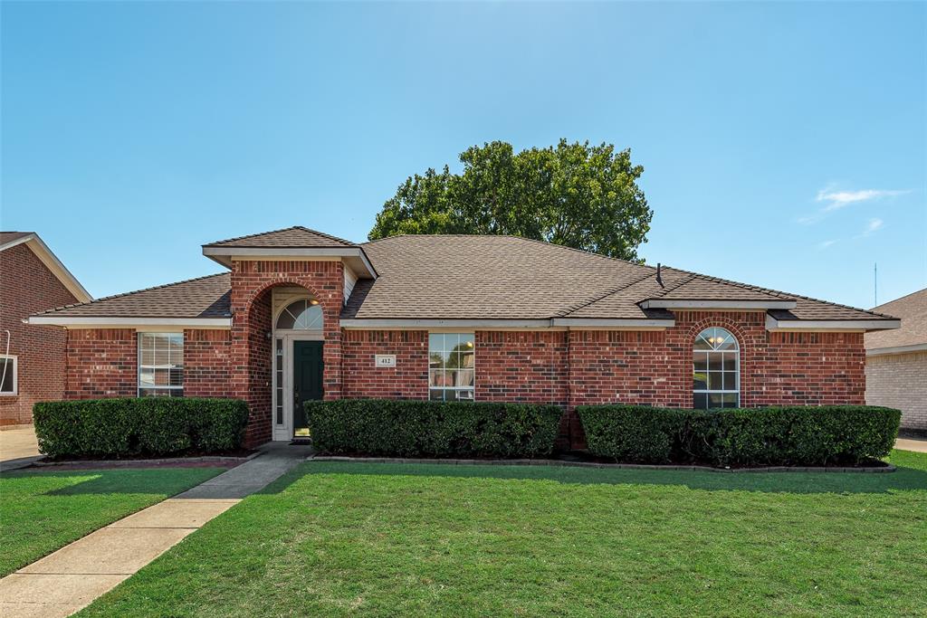 Single-story brick exterior featuring a covered entryway with an arched detail, multi-pane windows, and an asphalt shingle roof