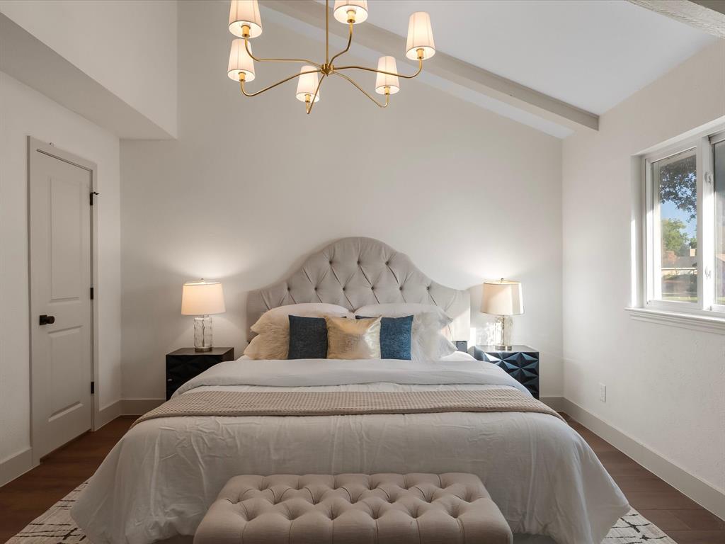 Vaulted ceilings, wood-finish flooring, and multi-arm chandelier with cream fabric shades